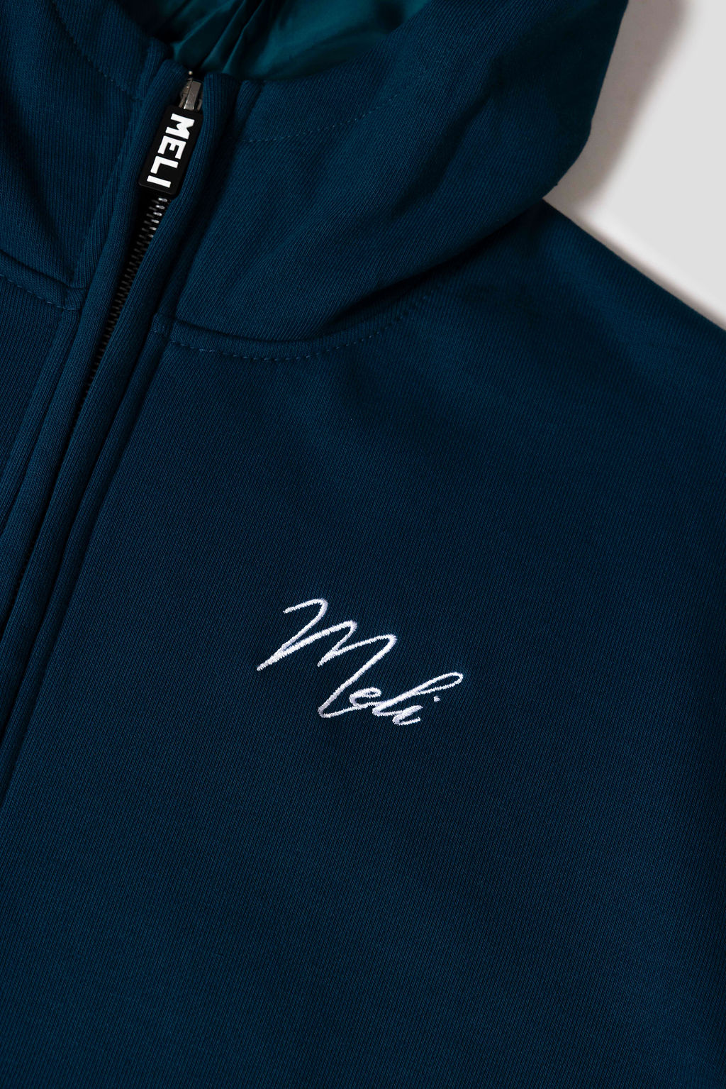 MELI Global Sweatsuit 3.0 in Atlantic, hidden half zip and embroidered MELI script at the chest
