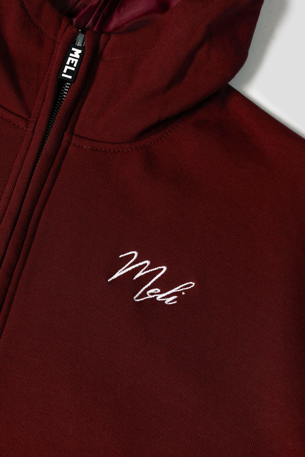 MELI Global Sweatsuit 3.0 in Crimson, hidden half zip and embroidered MELI script at the chest