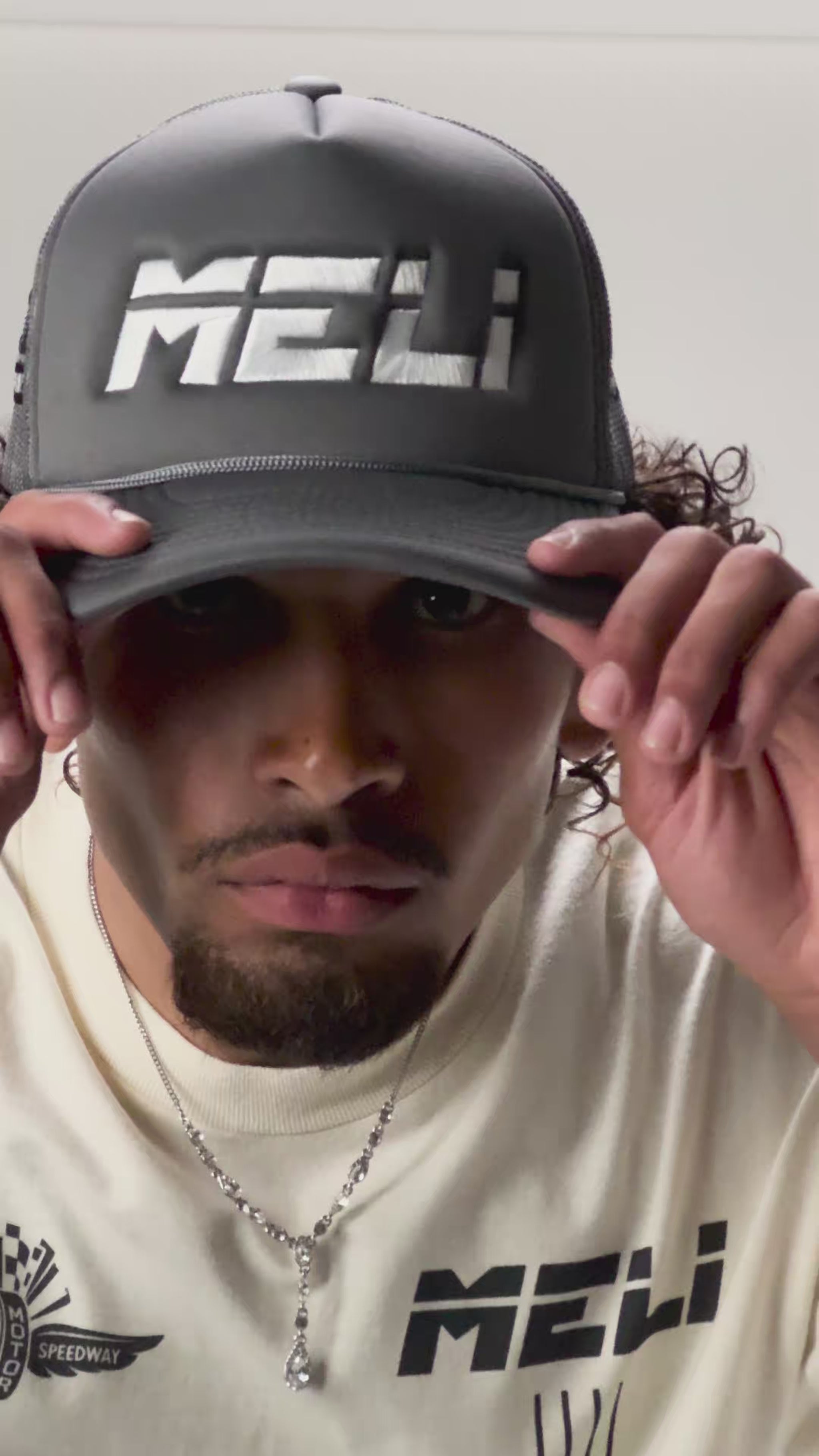 The MELI Motorsports trucker hat, worn